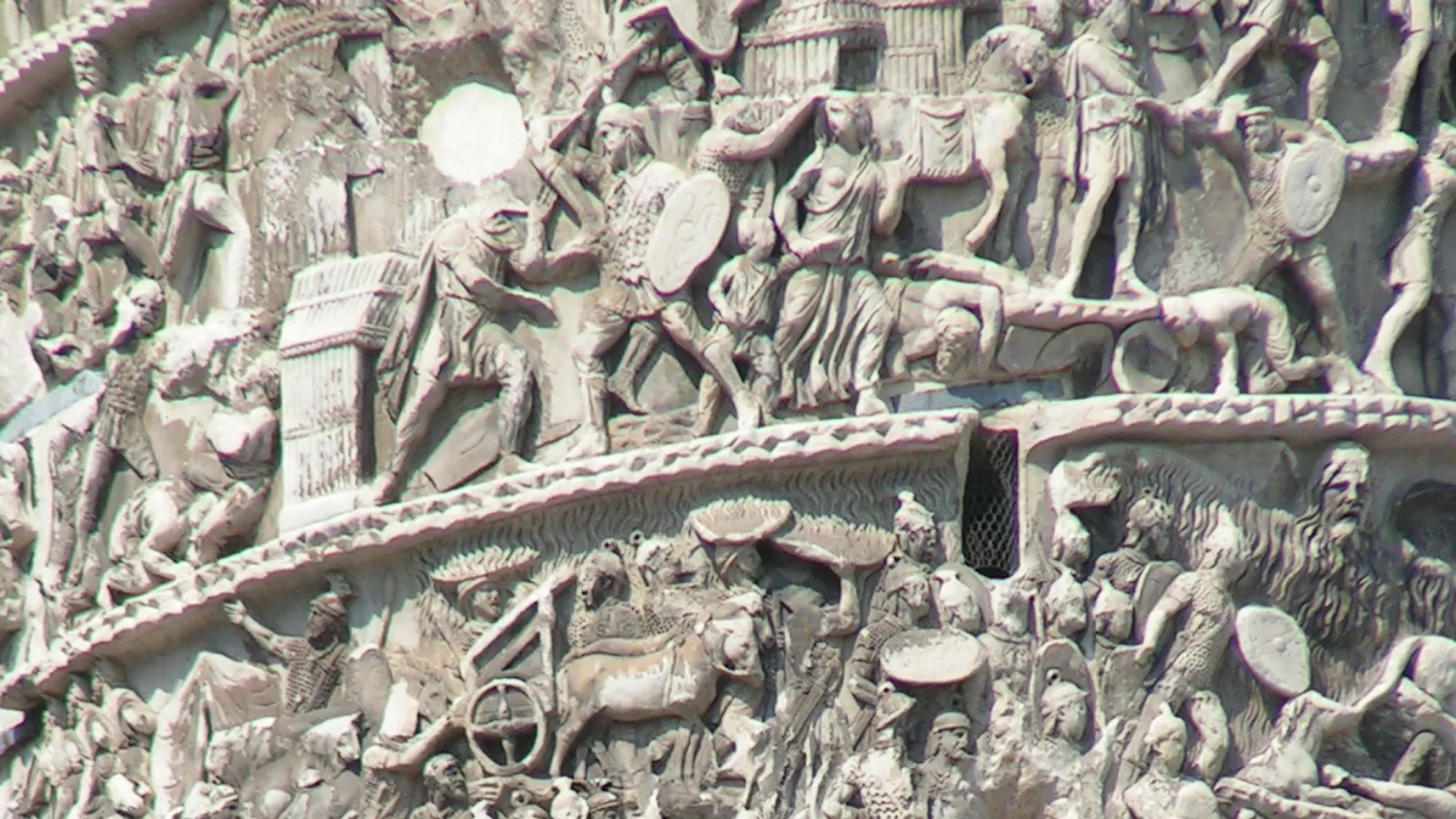 Detailed spiral relief on the Column of Marcus Aurelius showing Roman soldiers, barbarian captives, and a wagon scene from the Marcomannic Wars.