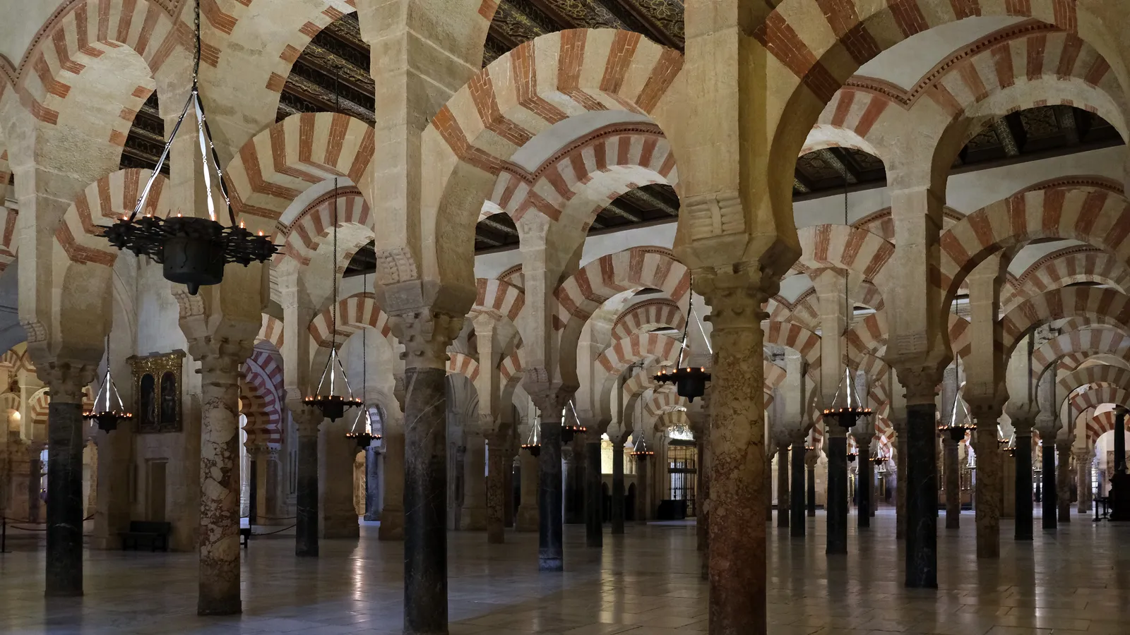 Interior view of the hypostyle prayer hall of the Mosque-Cathedral of Cordoba, with double-tiered red-and-white horseshoe arches.