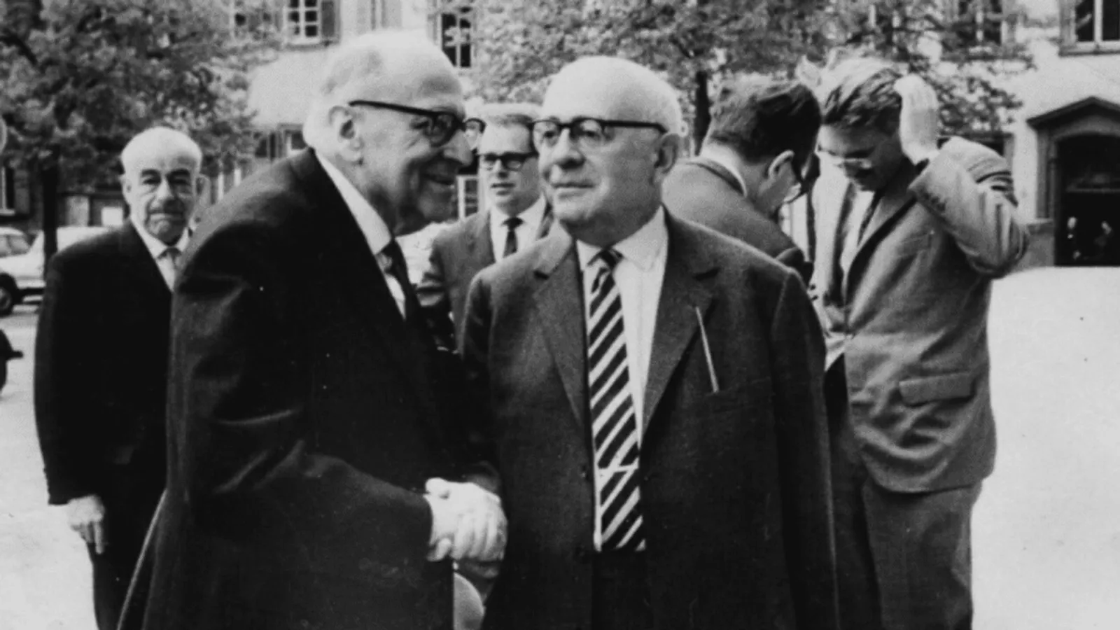 Heidelberg 1964: Adorno and Horkheimer in the foreground; Habermas behind, hand raised.