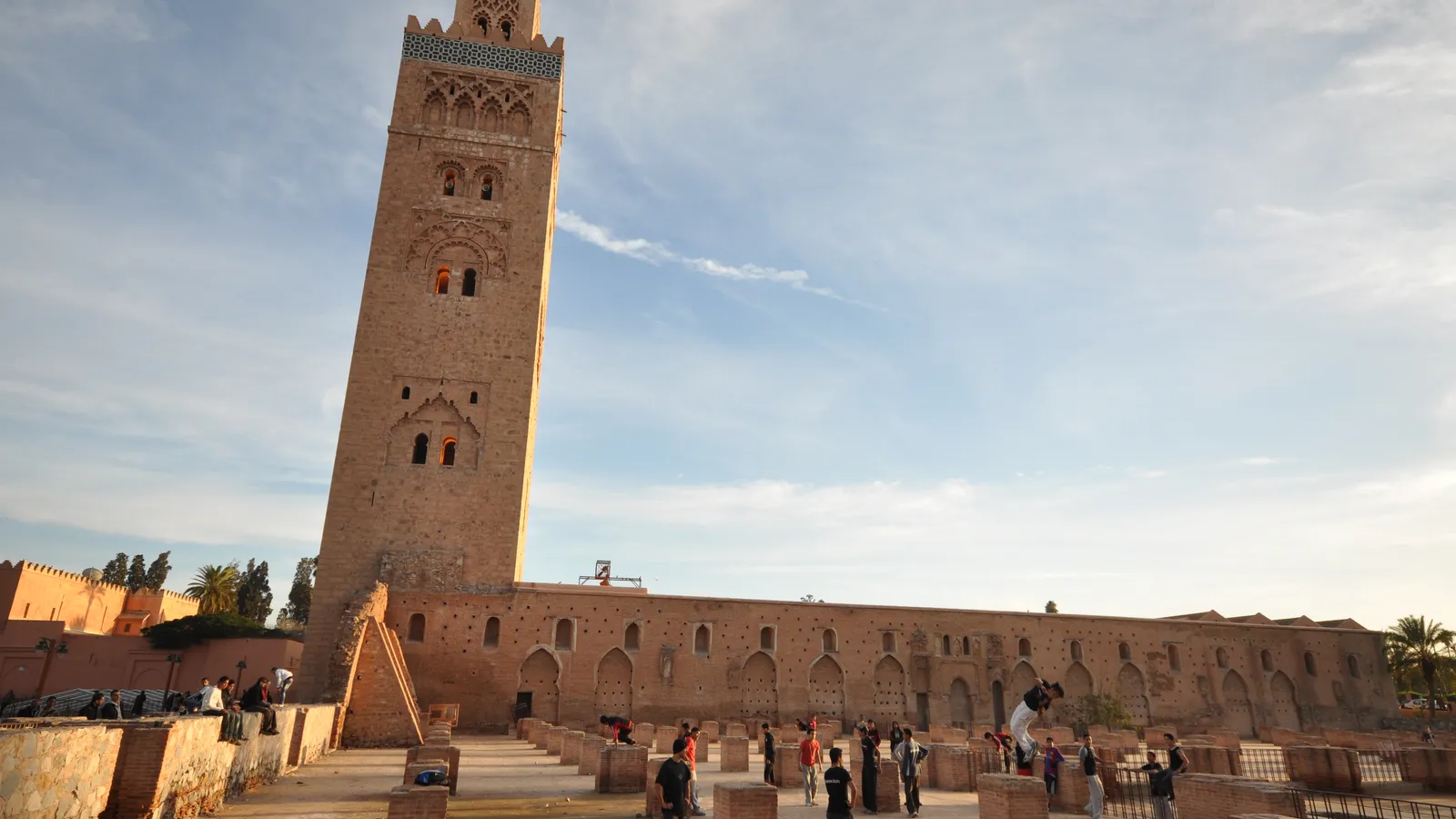 The Almohad-period Koutoubia mosque in Marrakesh at golden hour, its mudbrick minaret rising against a high desert sky.